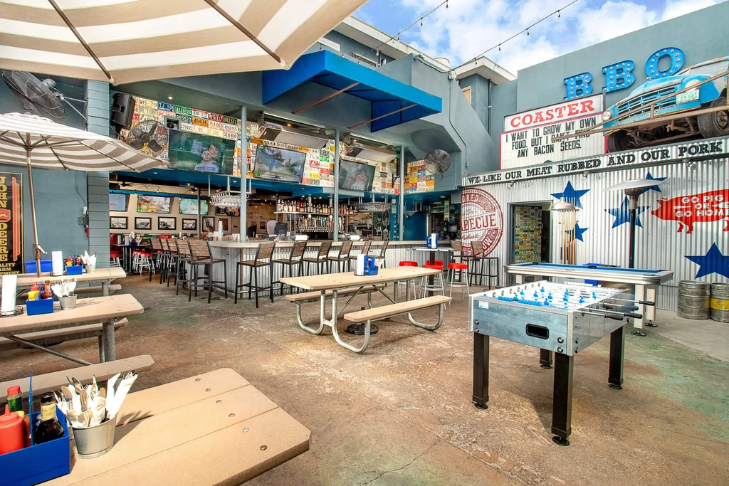 Spacious outdoor restaurant and bar patio with games and BBQ theme.