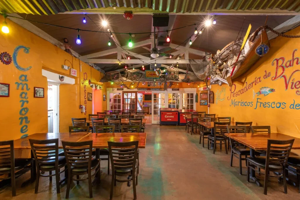 Colorful seafood restaurant interior with murals, string lights, and nautical decor.