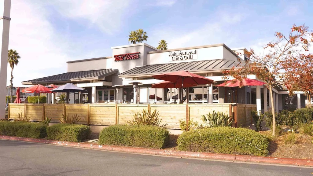 Single-story Fast Times Bar & Grill with outdoor patio and palm trees.