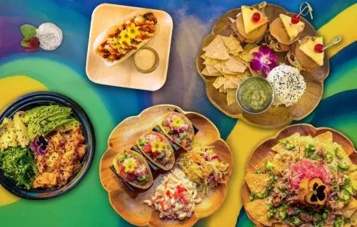 Overhead view of colorful Hawaiian dishes, some with edible flowers.