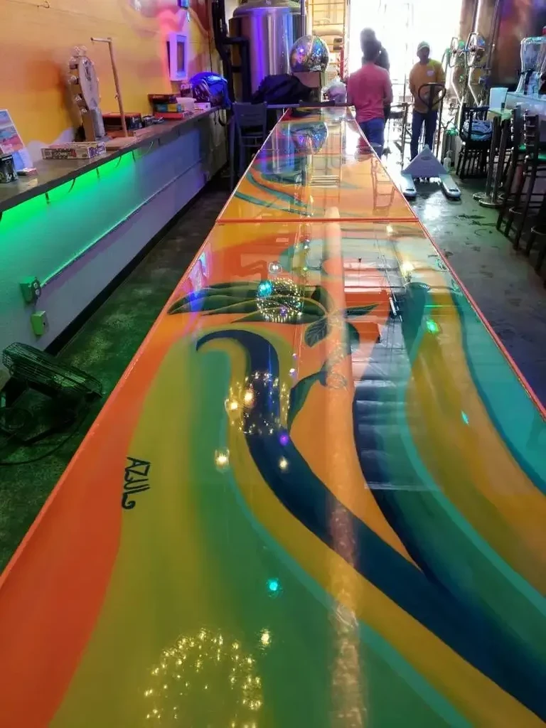 Colorful wavy bar counter and green-lit counter in a brewery.