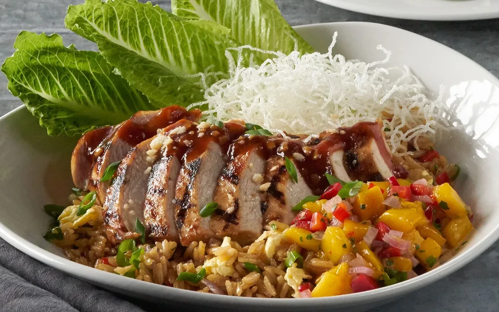 Sliced grilled chicken, fried rice, mango salsa, and romaine lettuce.