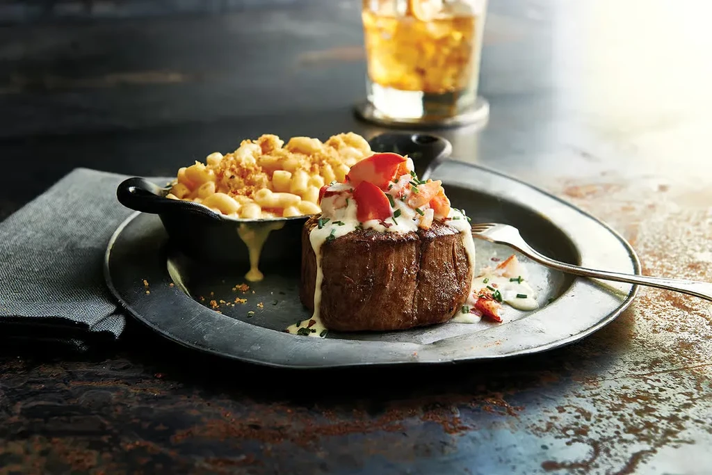 Thick steak with lobster, creamy sauce, and macaroni and cheese.