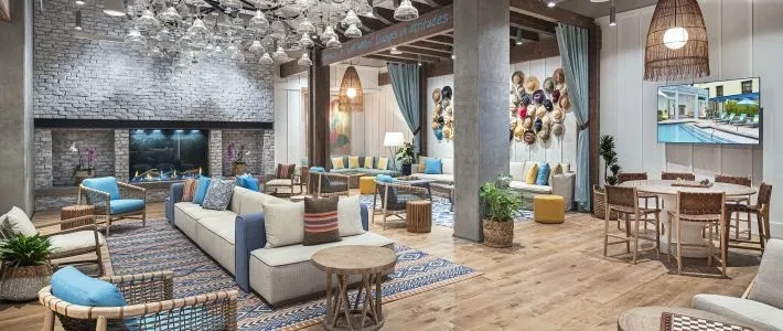 Modern lounge with fireplace, chandelier, varied seating, and wall art.