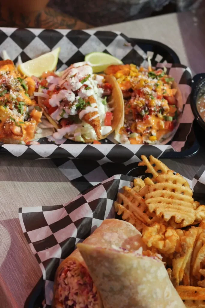 Fish tacos, waffle fries, and a burrito served in casual restaurant baskets.