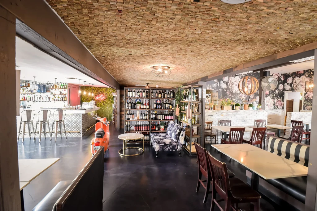 Eclectic restaurant interior with bar, lounge, dining, and an orange Vespa.