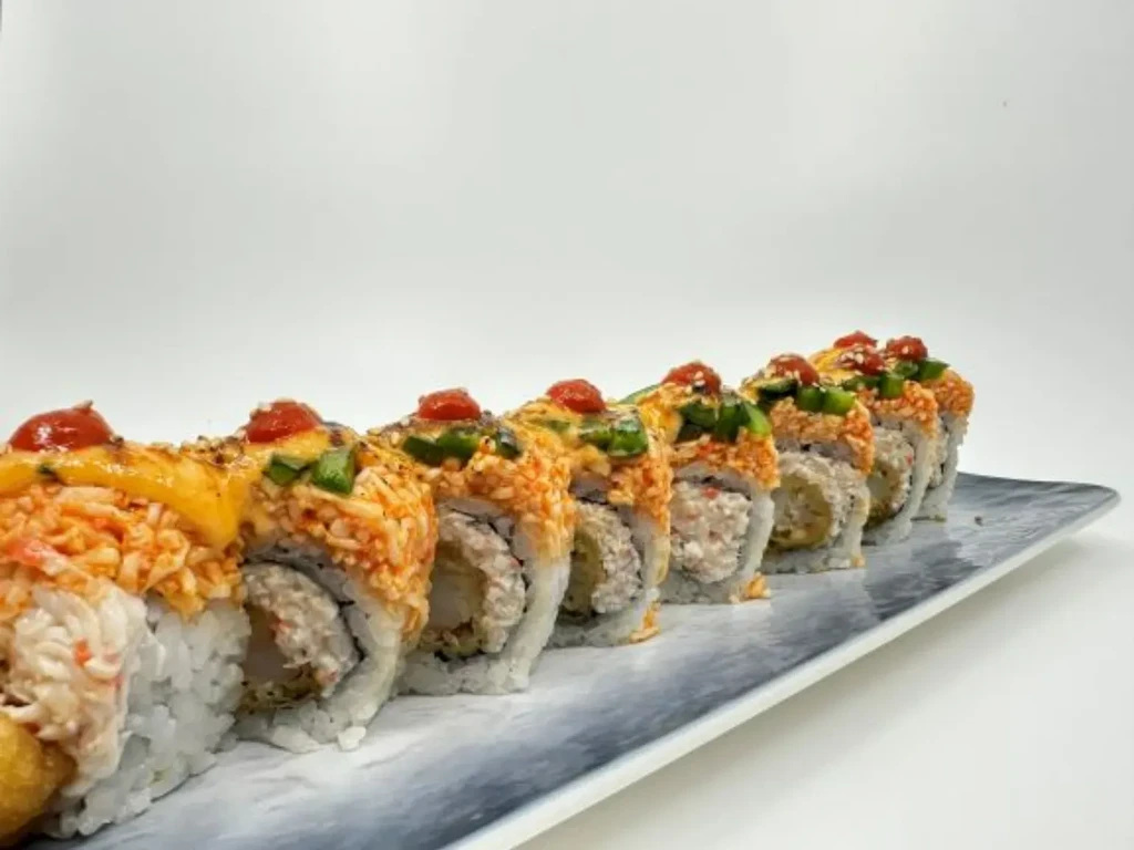 Seven inside-out sushi rolls with vibrant toppings on a mottled plate.