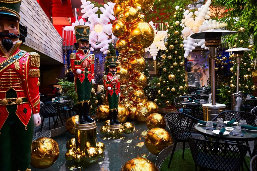 Elaborately decorated restaurant patio with nutcrackers, golden ornaments, and set tables.