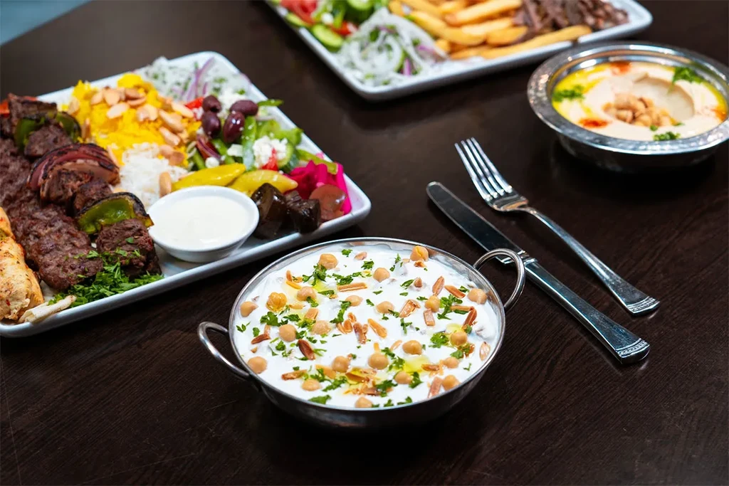 Middle Eastern kebabs, rice, dips, salad, and pickled vegetables.