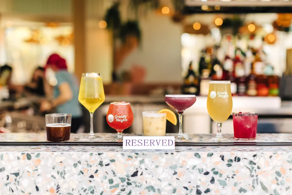 Six diverse alcoholic drinks and a 'RESERVED' sign on bar.