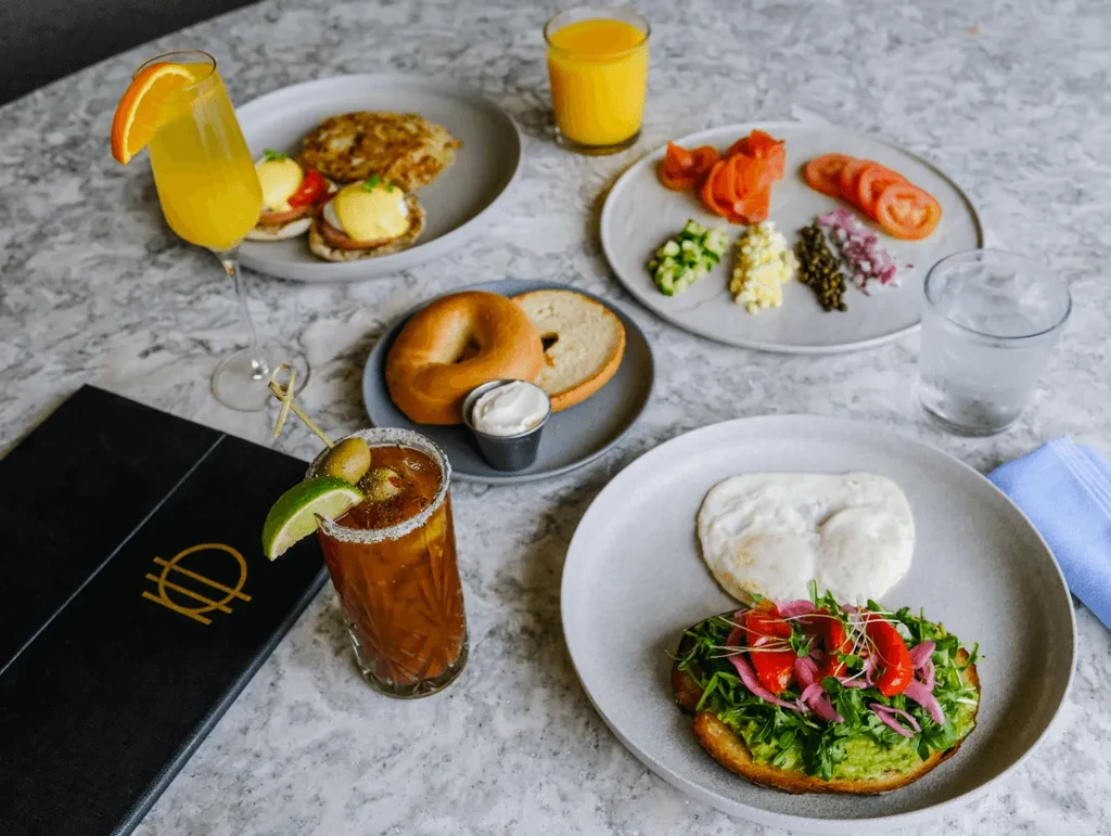 Vibrant breakfast and brunch spread with eggs, bagels, lox, and mimosas.