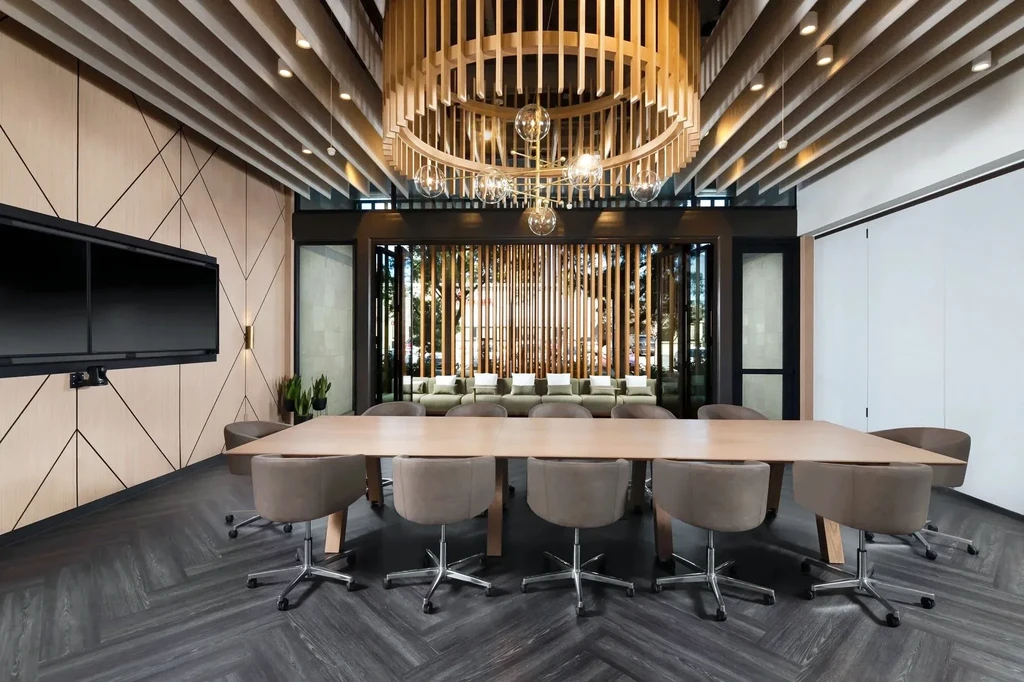Modern interior with long wooden table, chairs, and circular slat chandelier.