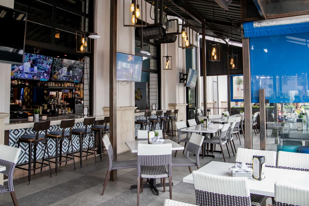 Modern restaurant with blue tiled bar and open-air dining.