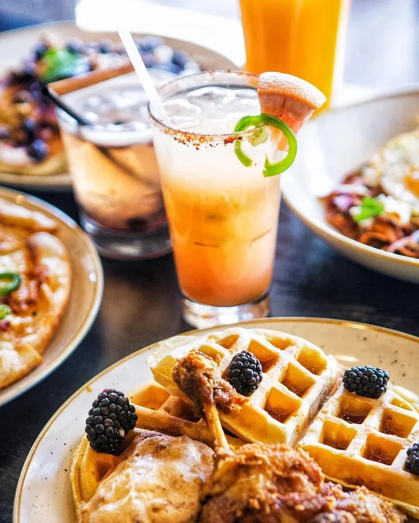 Waffles, fried chicken, and a jalapeño-garnished orange cocktail.