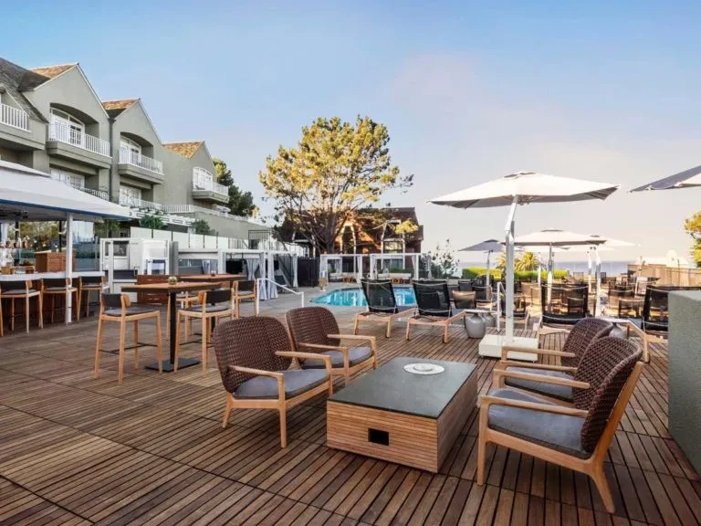 Spacious outdoor resort patio with lounge seating, bar, and pool.