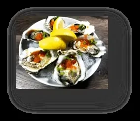 Fresh oysters on ice, garnished with red caviar, herbs, and lemon.