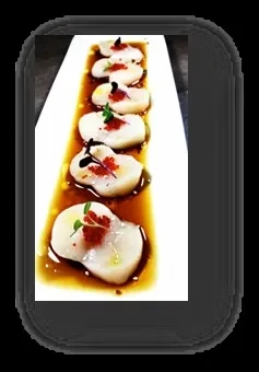 Five white seafood/vegetable pieces with red roe, greens, dark sauce.