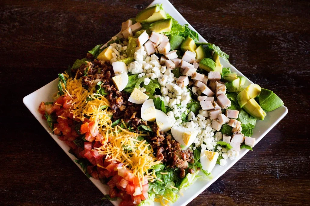 Overhead Cobb-style salad with chicken, egg, avocado, and cheese.