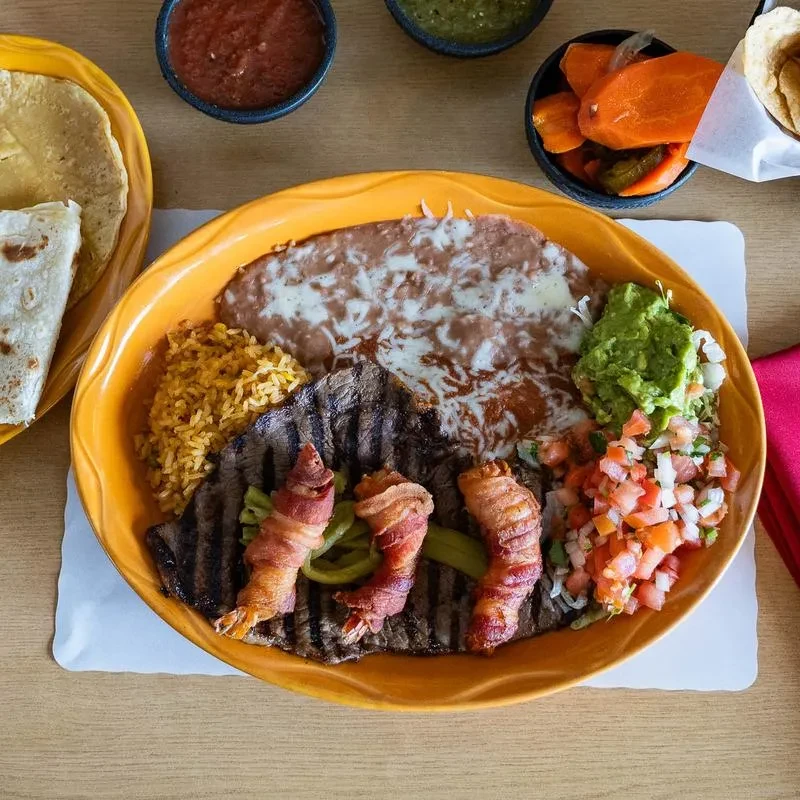 Carne asada, bacon shrimp, rice, beans, guacamole, and pico de gallo.