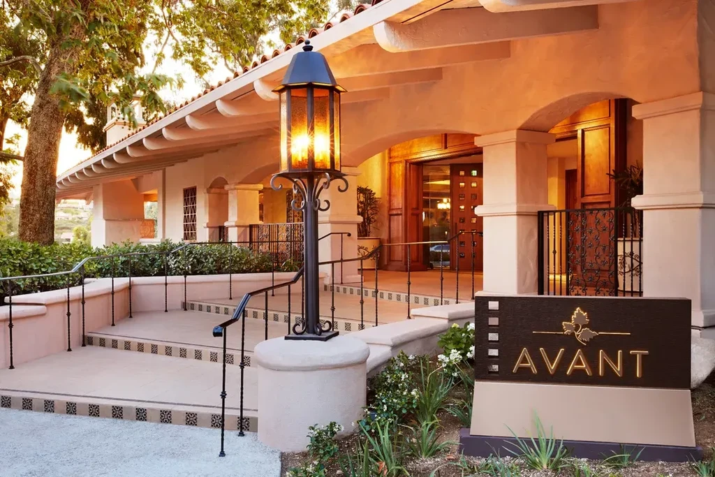 Spanish colonial restaurant exterior at dusk with "AVANT" sign.