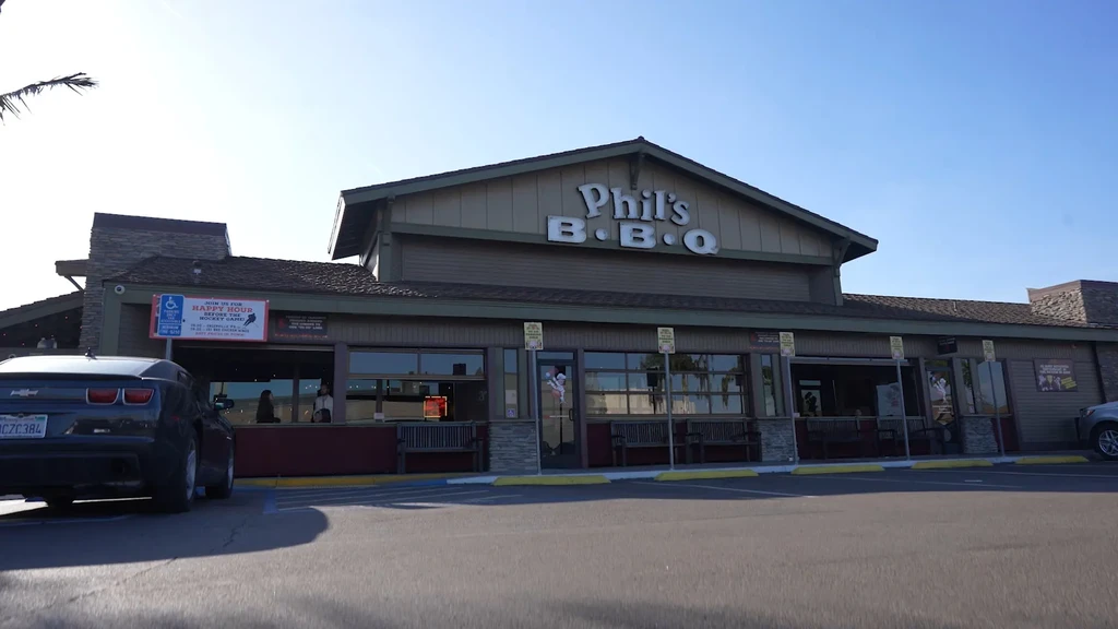 Phil's B•B•Q restaurant exterior with siding, stone, and roll-up windows.