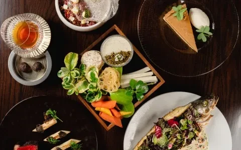 Overhead shot of a luxurious fine dining spread on a dark table.