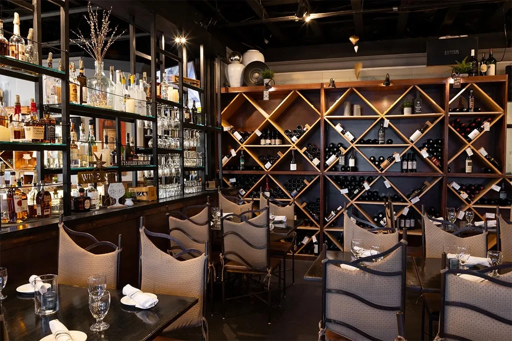 Elegant restaurant interior with a liquor bar and extensive wine rack.