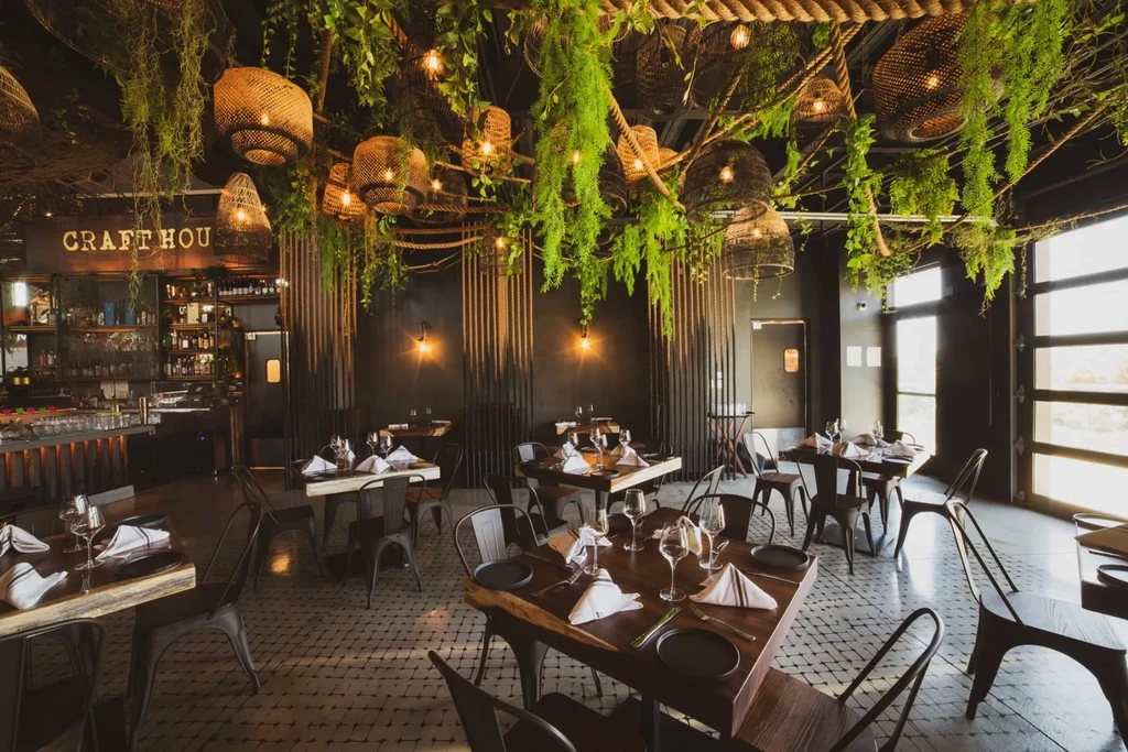 Jungle-themed Craft House restaurant with hanging plants and warm lights.