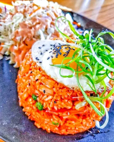 Kimchi fried rice with sunny-side-up egg, black sesame, and green scallions.