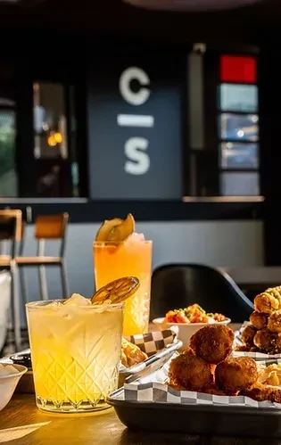 Vibrant cocktails and fried food on a modern restaurant table.