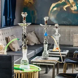 Three ornate hookahs with hoses displayed in a modern lounge.