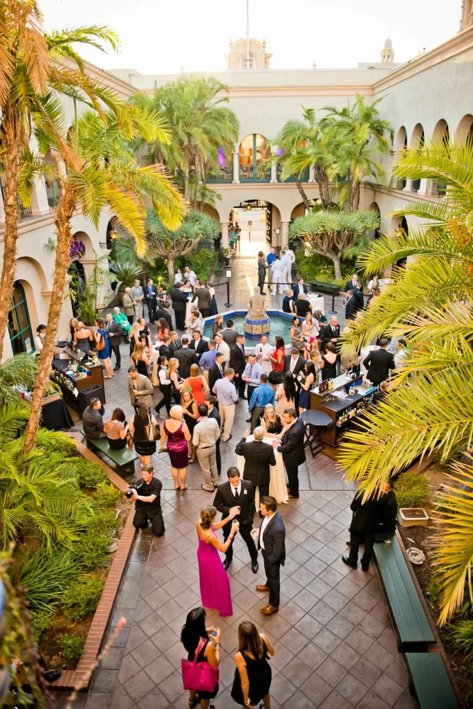 High-angle formal outdoor event with palms in a Mediterranean courtyard.
