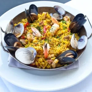 Top-down view of seafood paella with mussels, clams, and shrimp.