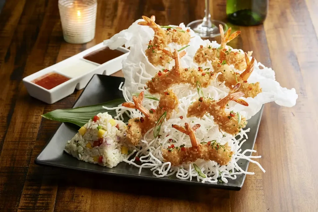 Golden-fried shrimp, colorful rice, rice noodles, and three sauces.