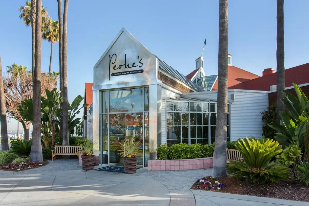 Exterior of Peohe's restaurant, metallic facade, tropical palms, waterfront.