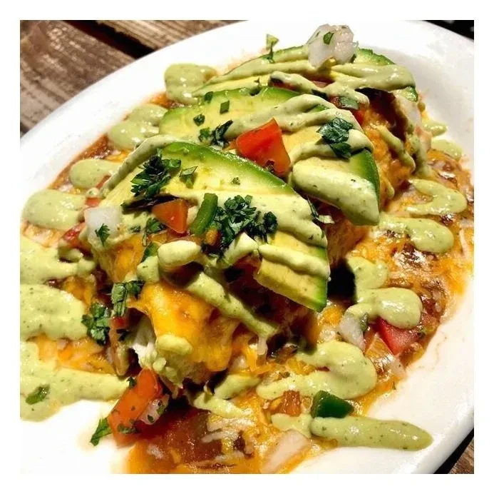 Cheesy Mexican dish with avocado, tomatoes, onions, and cilantro.