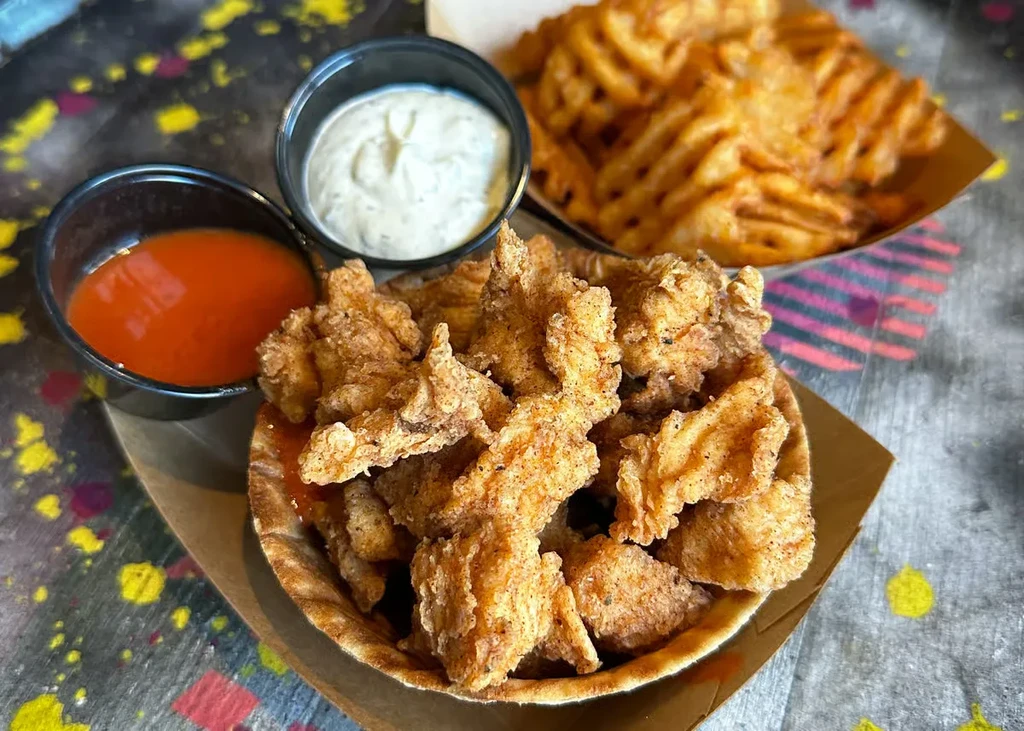 Fried tenders and two dipping sauces, with waffle fries.