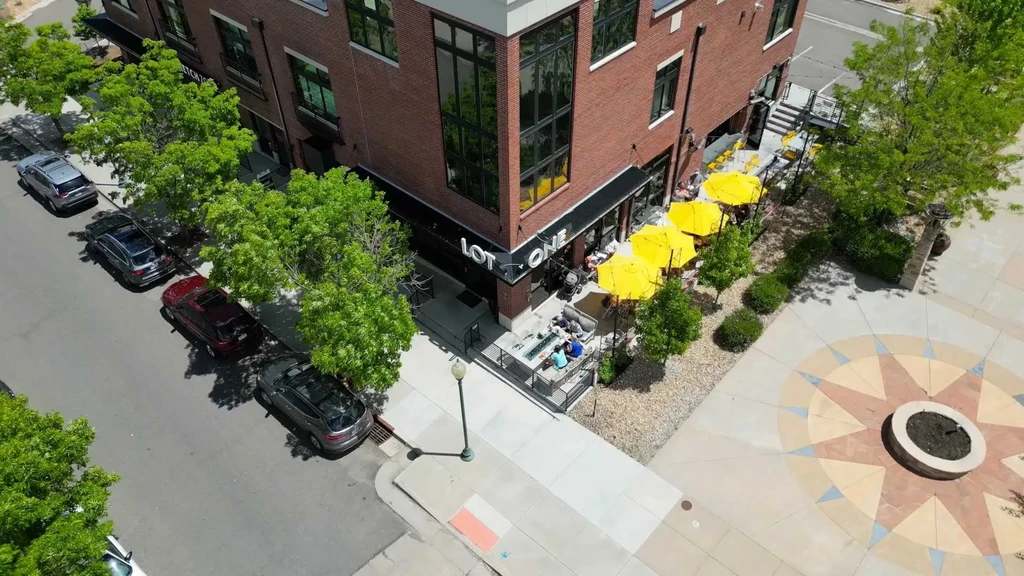 Aerial view: Lot One restaurant, outdoor seating, fire pit, public plaza.