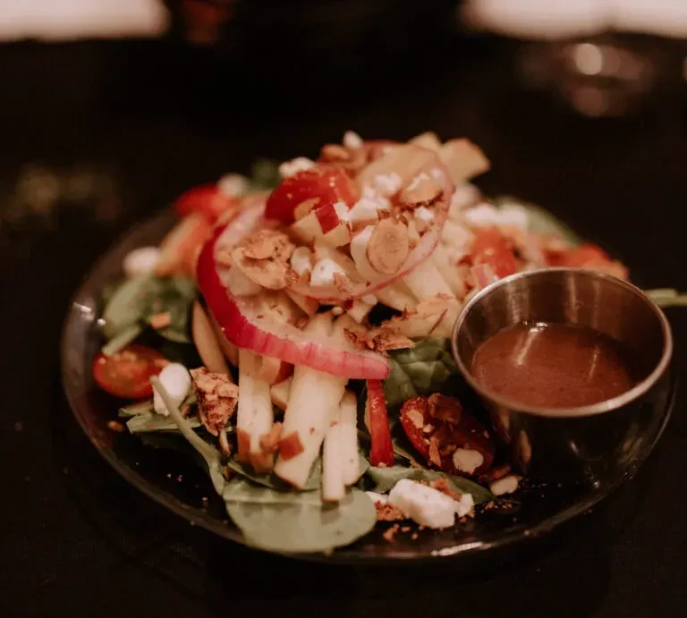 Mixed greens salad with apples, cheese, tomatoes, nuts, and dressing.