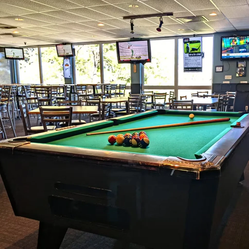 Green felt pool table ready for play in a casual restaurant.