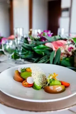 Heirloom tomato and radish appetizer with green purée, flowers, and crisp.