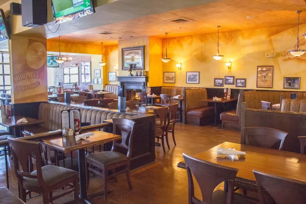 Traditional Irish pub with dark wood, murals, and sports TVs.