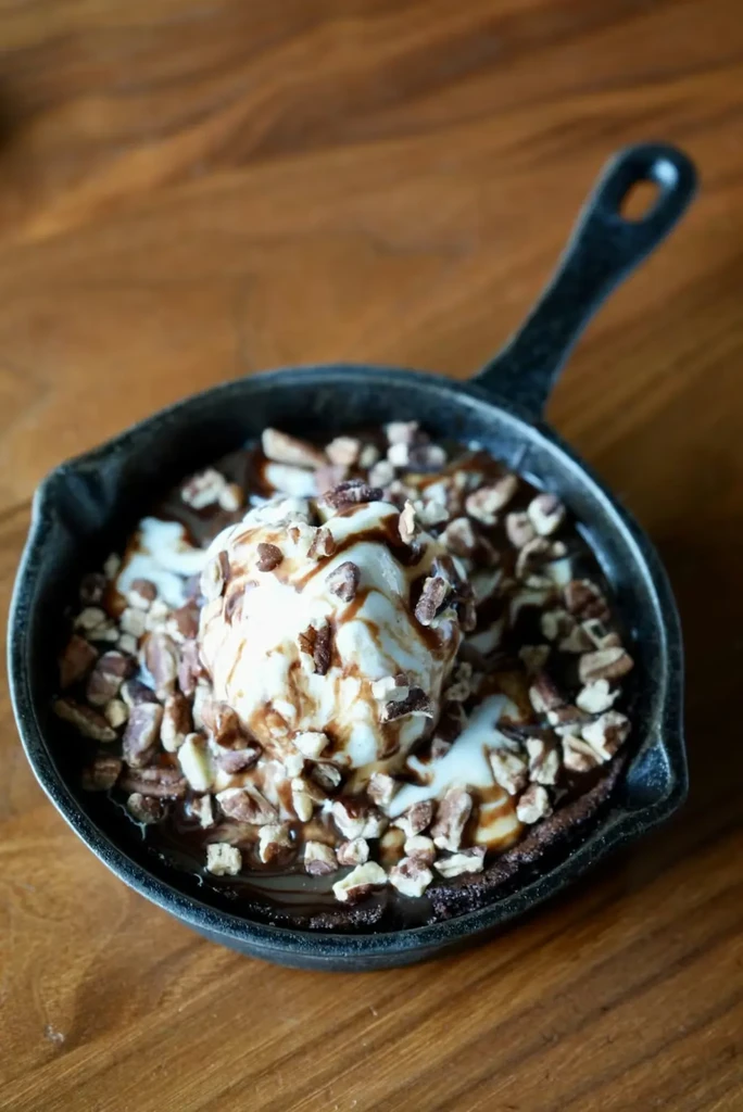 Warm chocolate dessert, melting vanilla ice cream and nuts in a skillet.