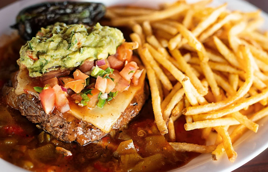 Hearty patty with melted cheese, pico, guacamole, sauce, and golden fries.