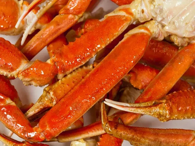 Close-up of vibrant, glossy orange-red cooked crab legs.