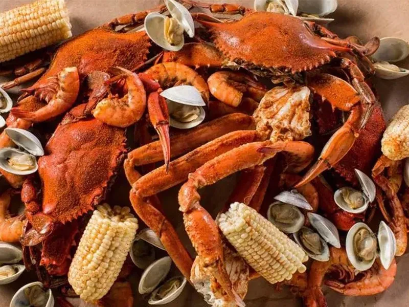 Cooked crabs, shrimp, clams, and corn in a seafood boil.