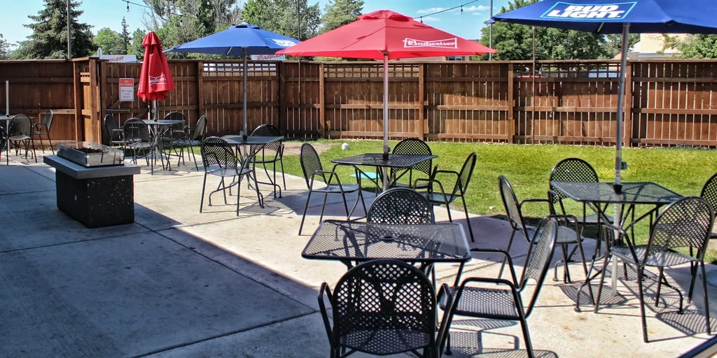Restaurant patio with Budweiser/Bud Light umbrellas, tables, chairs, and fire pit.