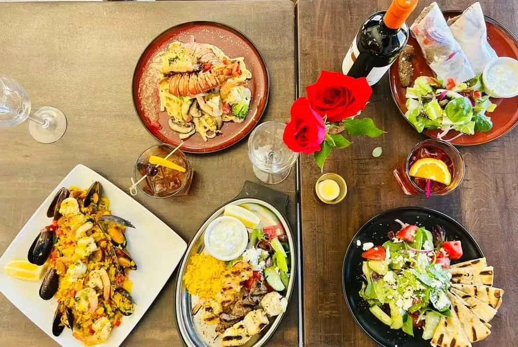 Top-down view of a lavishly set dining table with diverse food and drinks.