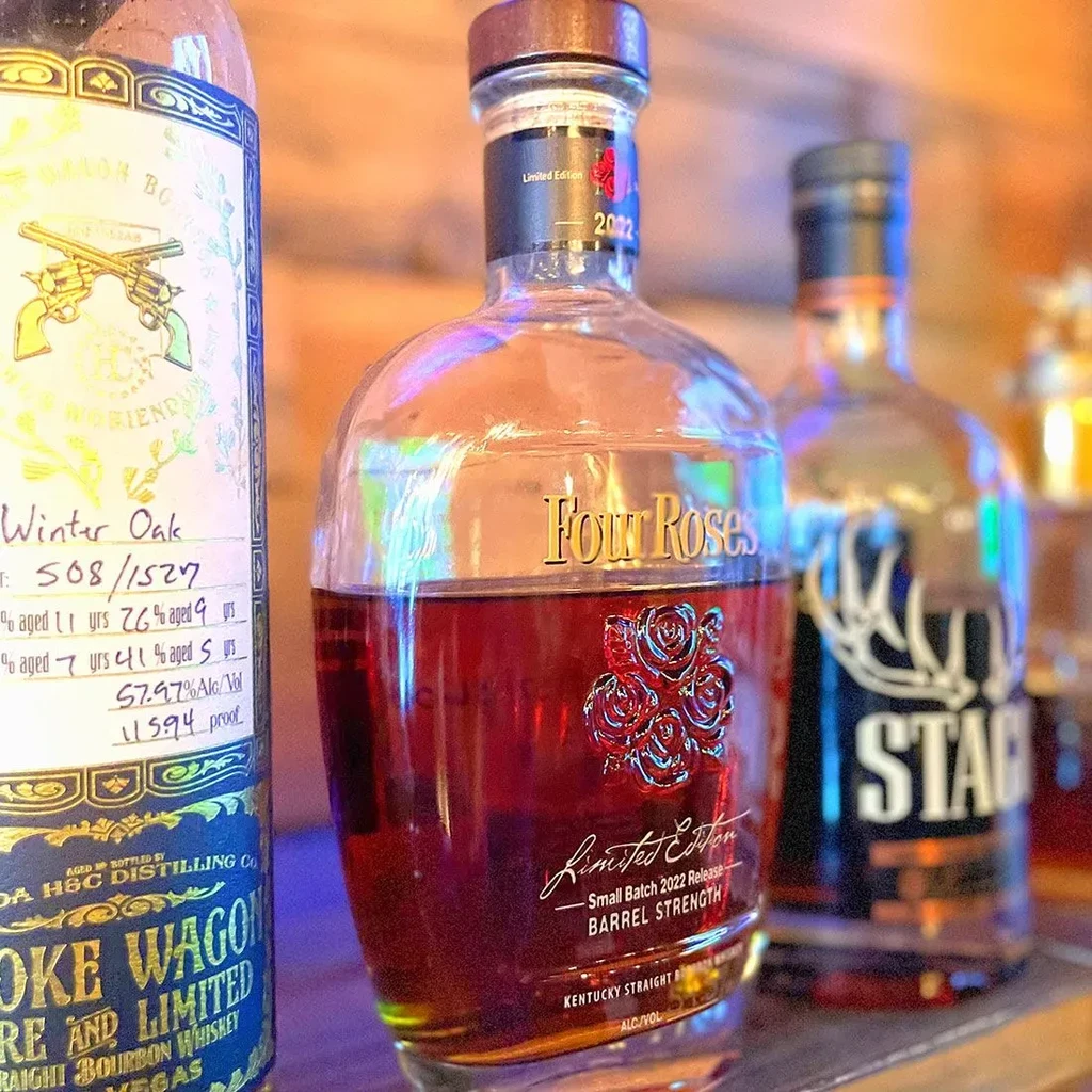 Four Roses, Smoke Wagon, and Stagg bourbon bottles on display.