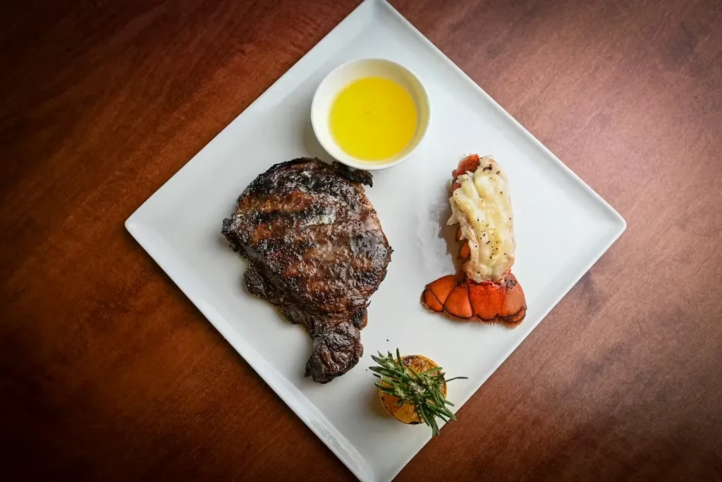 Grilled steak, lobster tail, melted butter, roasted lemon, and rosemary.